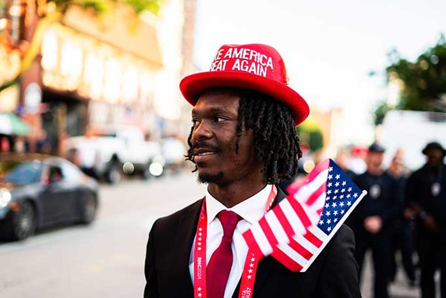 A Black Trump supporter holds the American flag.