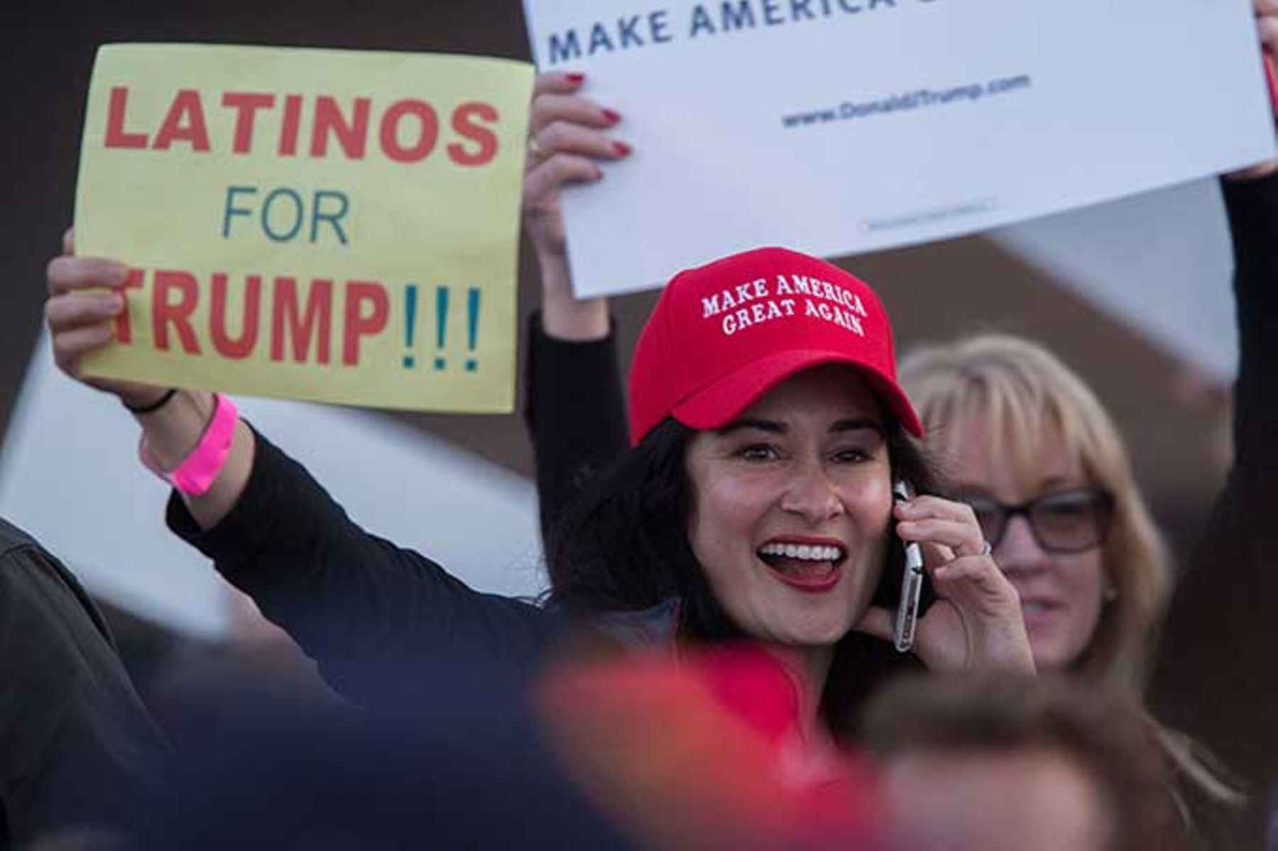 A woman hoods a sign expressing Latino support for Republican presidential candidate Donald Trump.