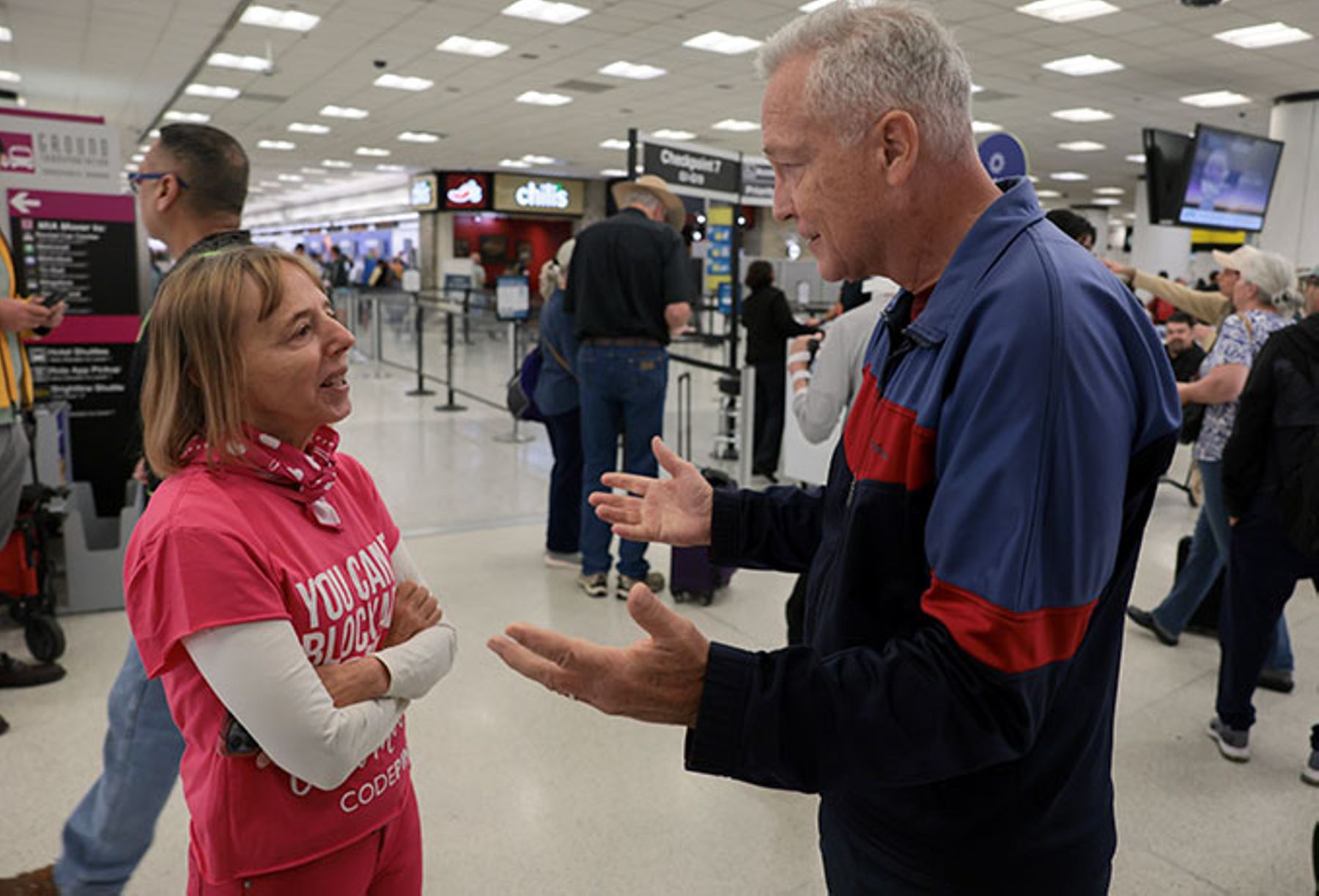 Medea Benjamin, from CODEPINK, speaks with Phil Ehr, who is against her and others' efforts to send boxes of humanitarian aid to Cuba.