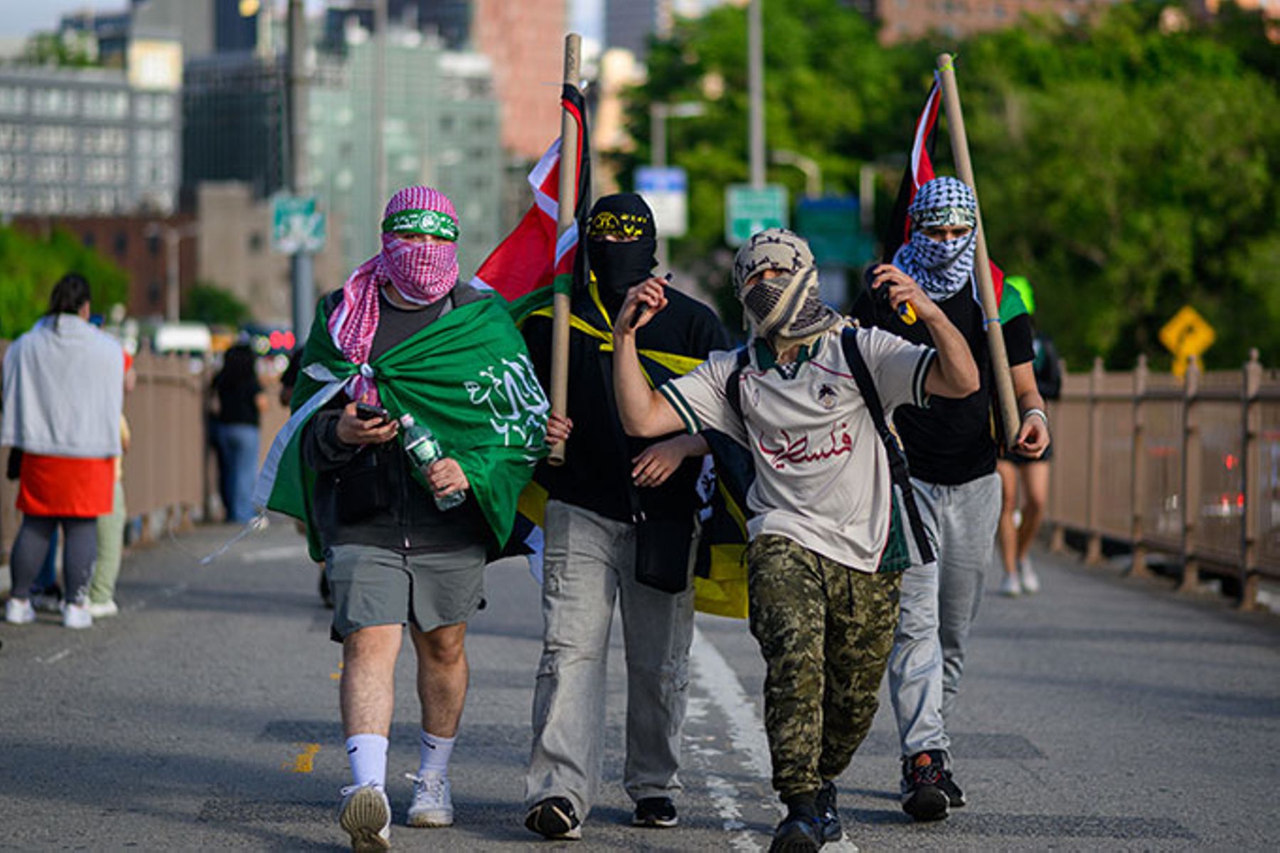 Pro-Palestinian protestors march across the Brooklyn Bridge carrying flags during Nakba Day protests on May 15, 2025.