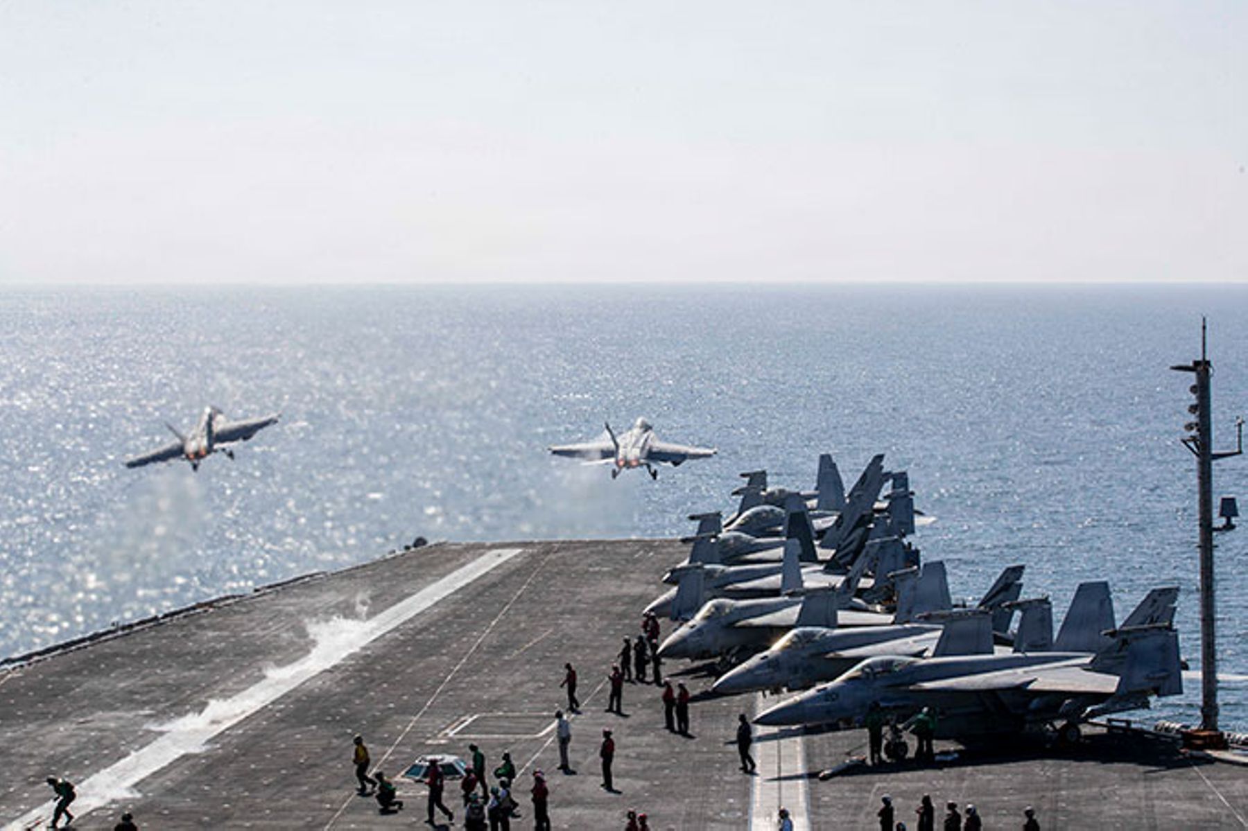 Two F/A-18 Super Hornets launch from the flight deck of Nimitz-class aircraft carrier USS Abraham Lincoln in support of Operation Epic Fury.