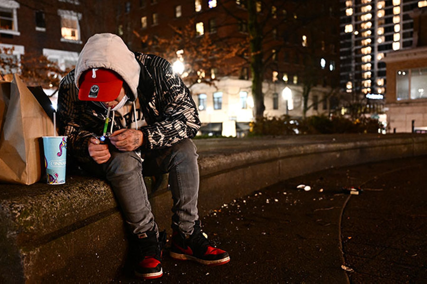 A person is using fentanyl on Park Avenue following the decriminalisation of all drugs in downtown Portland, Oregon on January 23, 2024.